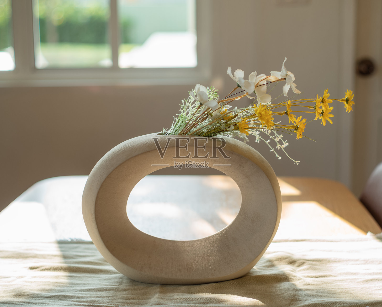 木桌上的花瓶里插着假花照片摄影图片