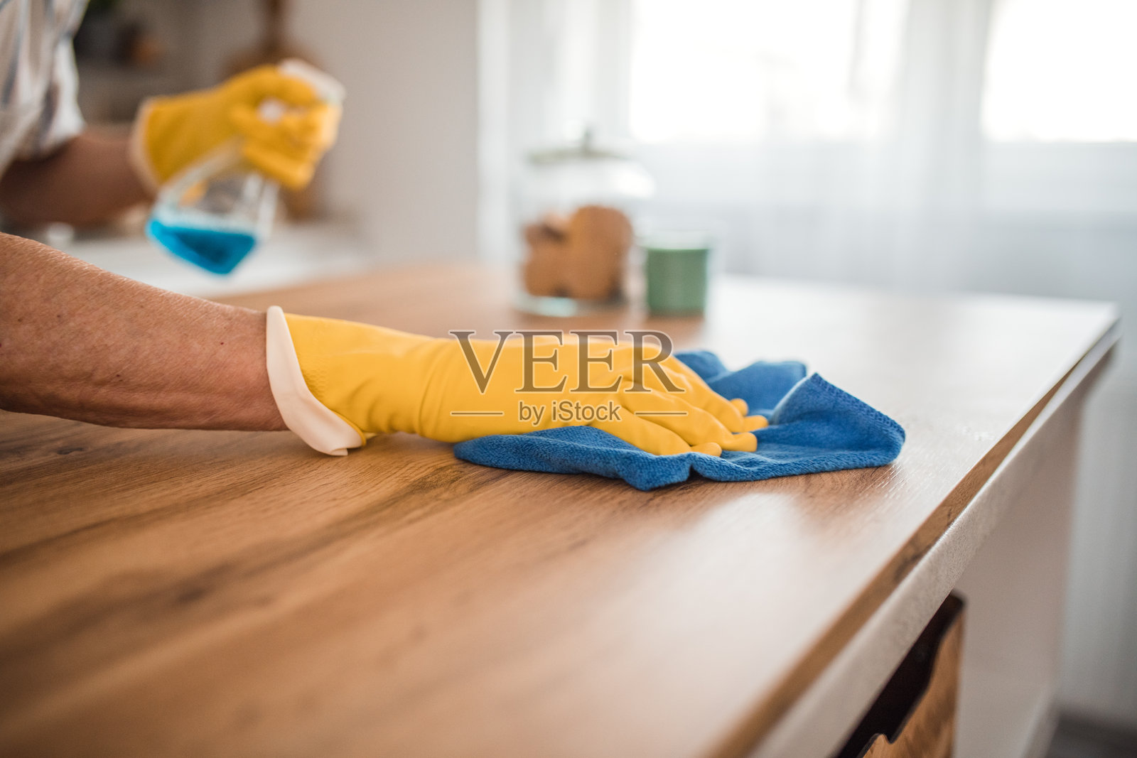 一个戴着手套的老人在打扫厨房柜台时的特写镜头照片摄影图片