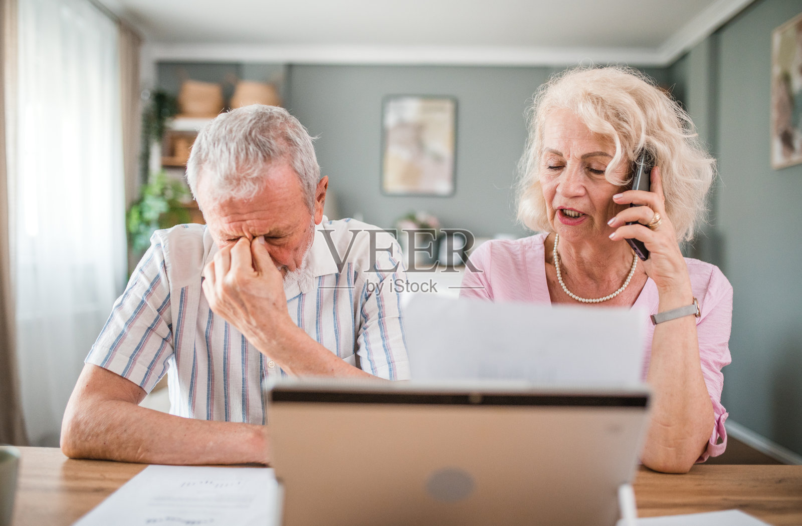 一位成熟的女士正在用手机和银行通话。她和她的丈夫正在经历他们必须解决的经济问题照片摄影图片