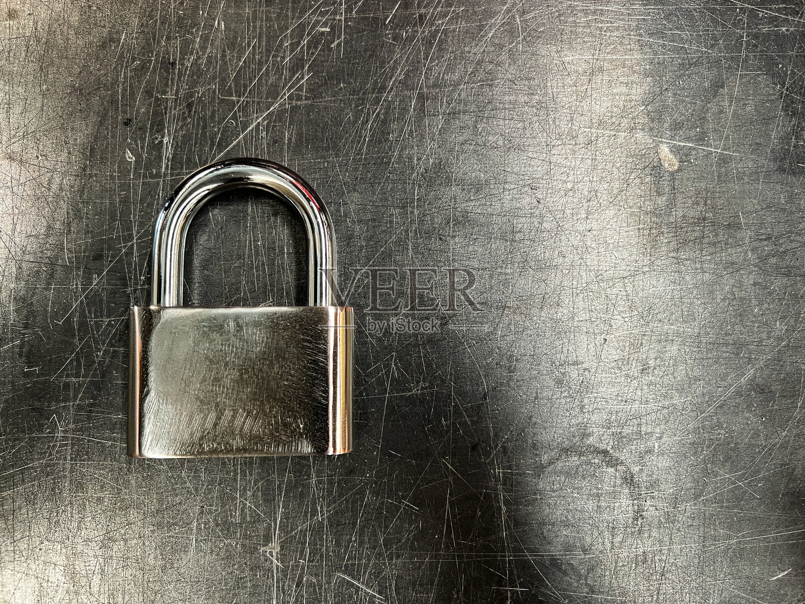 金属纹理背景上的金属挂锁照片摄影图片