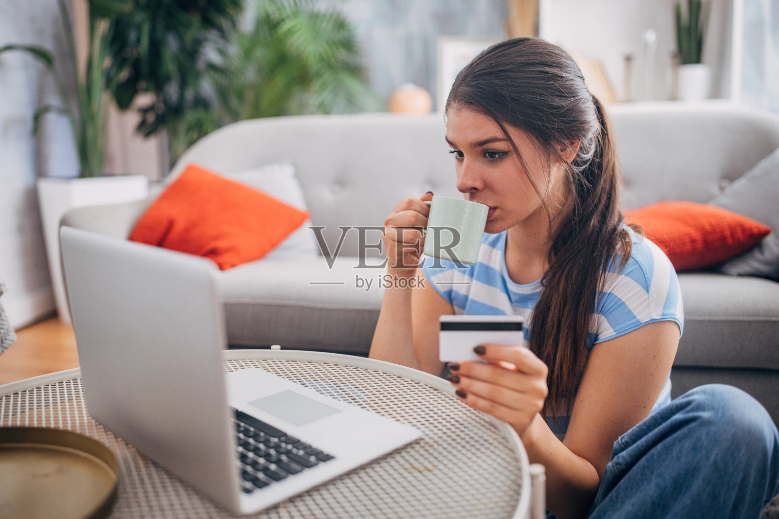 女人一边在家里网购一边喝咖啡照片摄影图片