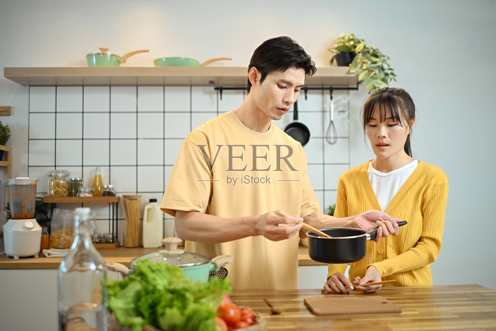 幸福的年轻夫妇在简约的厨房里用新鲜的食材一起准备饭菜照片摄影图片