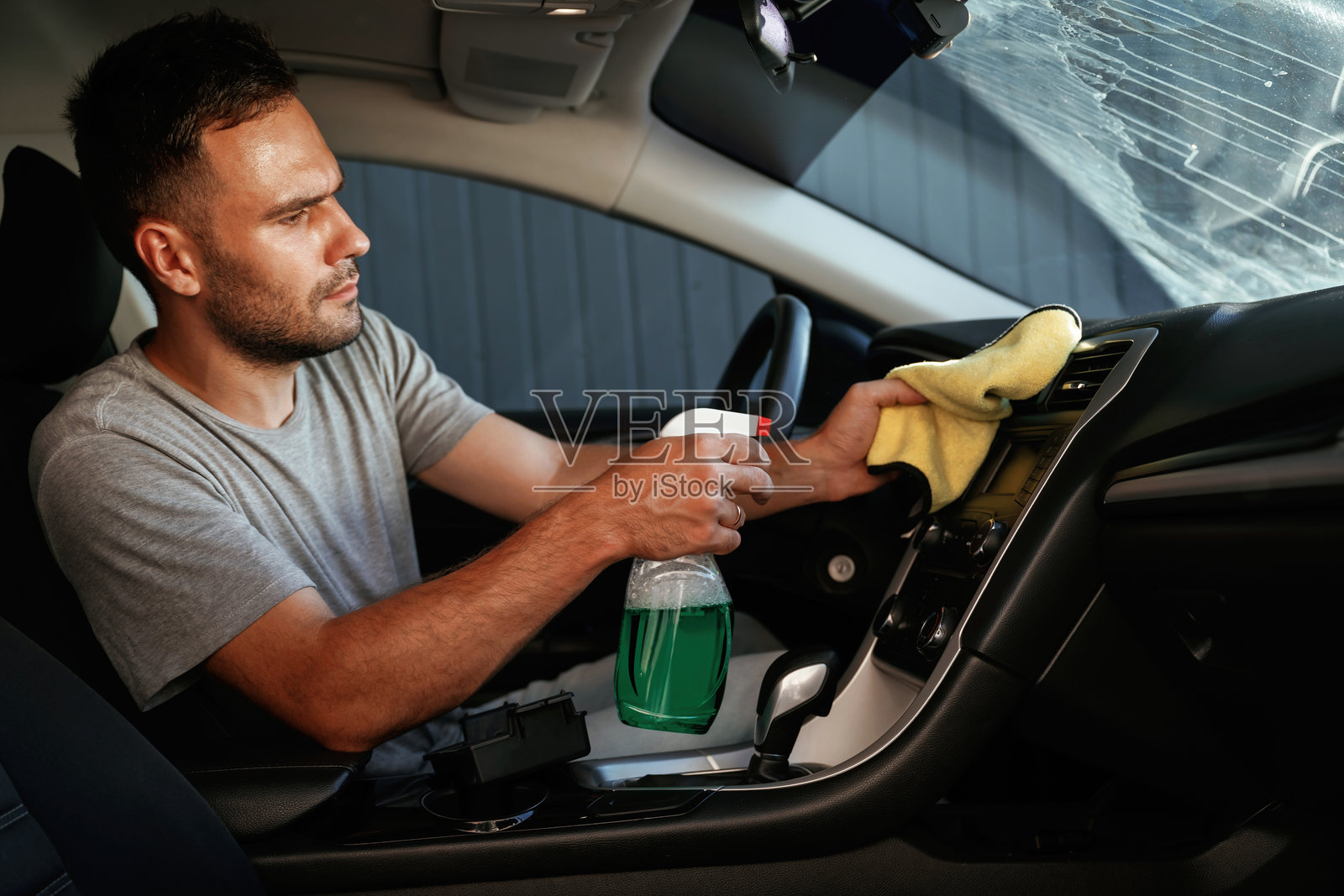 新鲜的喷雾。一个人正在清洗他的汽车内部照片摄影图片