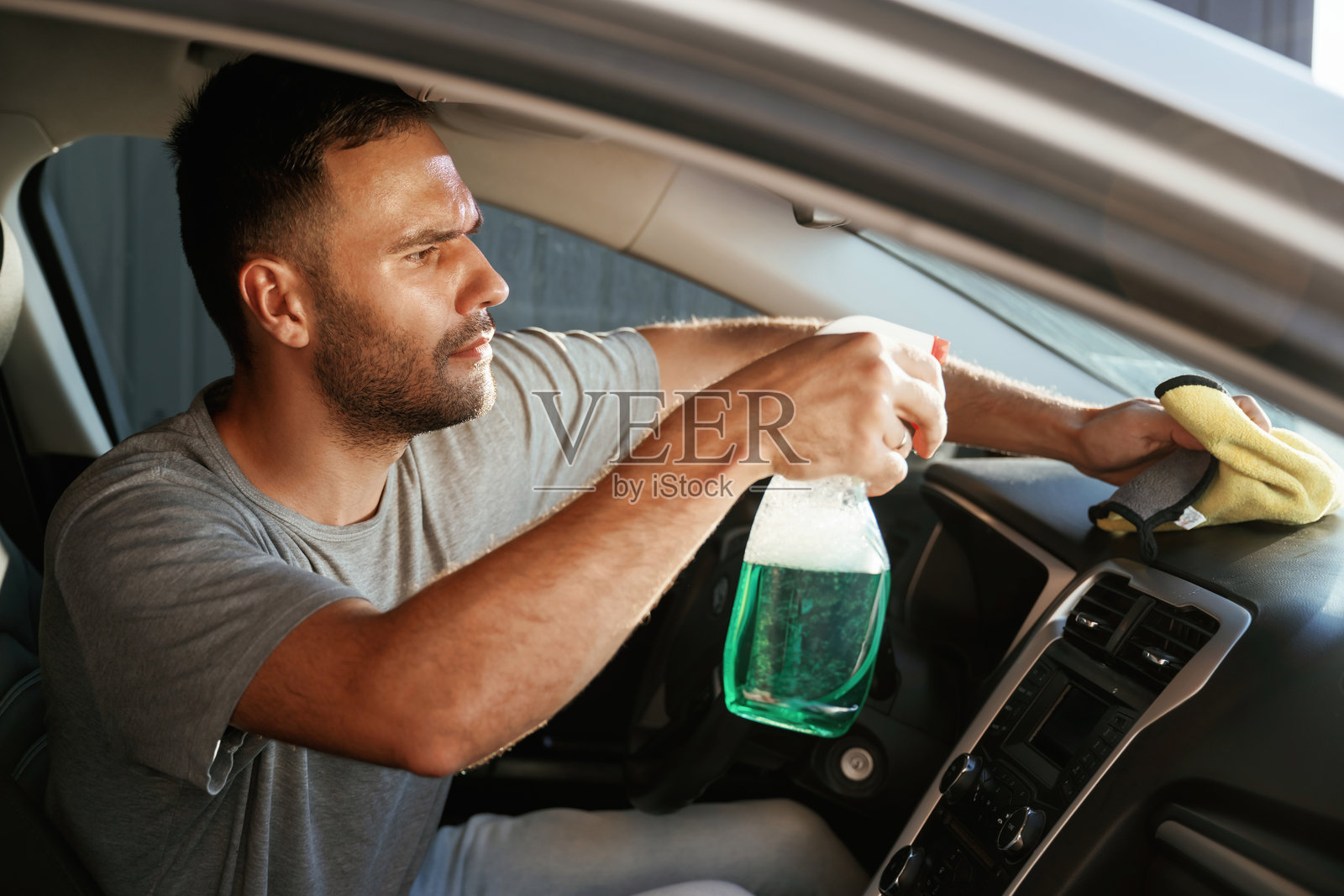 新鲜的喷雾。一个人正在清洗他的汽车内部照片摄影图片