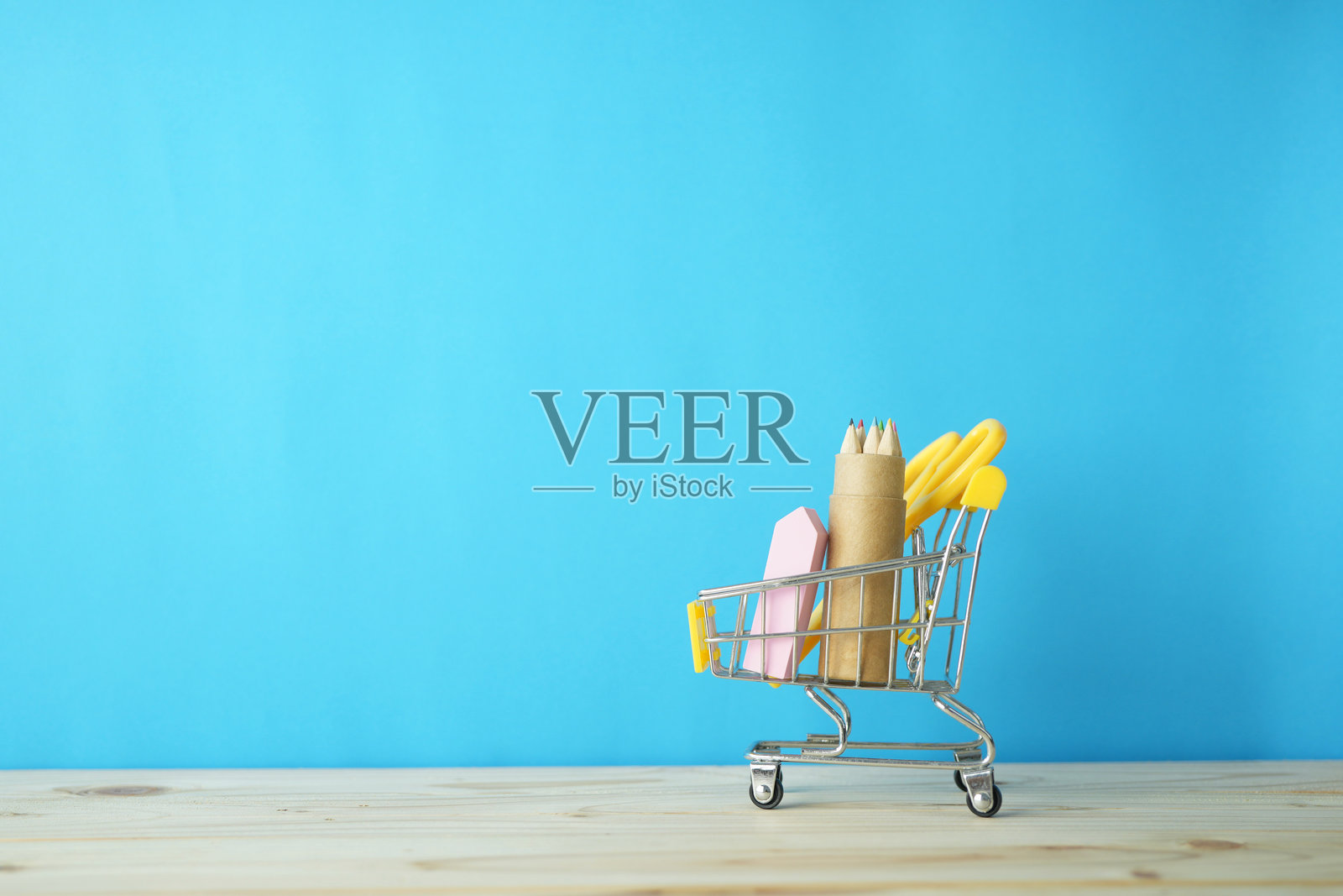 回到学校用品，橡皮，彩色铅笔在一个纸盒里的迷你购物车照片摄影图片