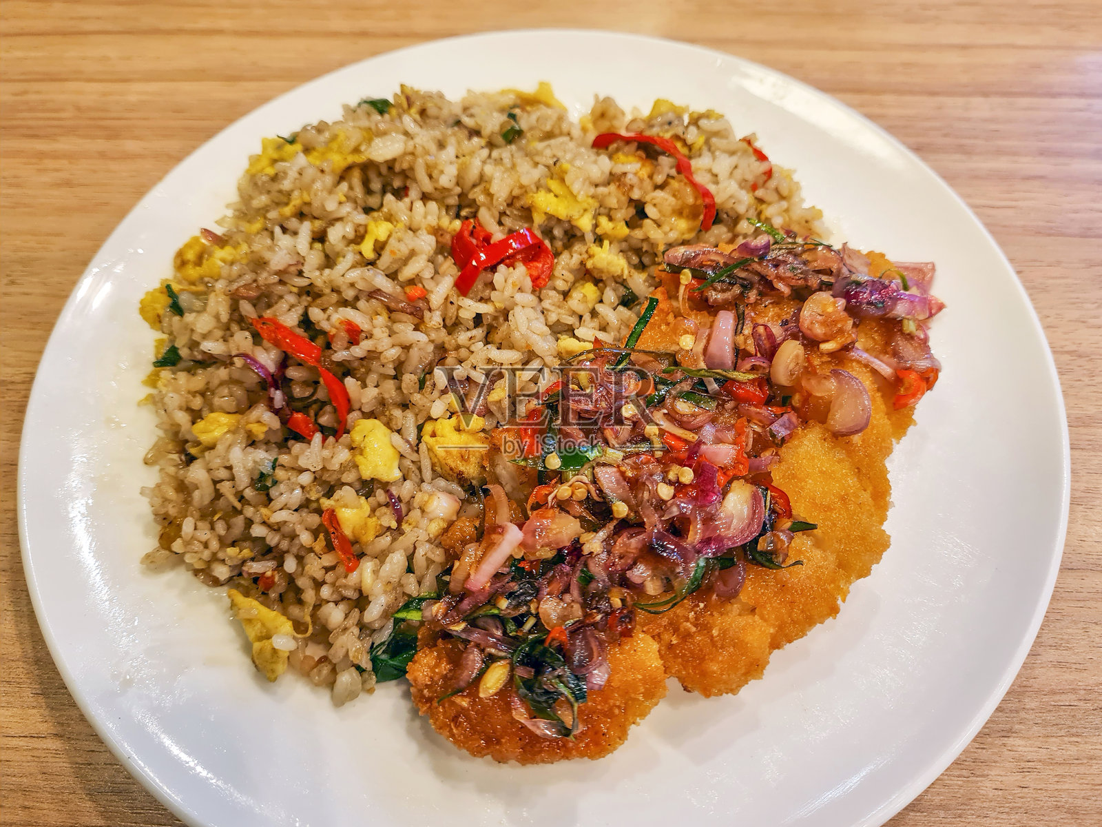 将印尼和日本的食物混合放在盘子里，配上炒饭或炒饭，再配上辣味的巴厘岛参巴玛塔配菜。照片摄影图片