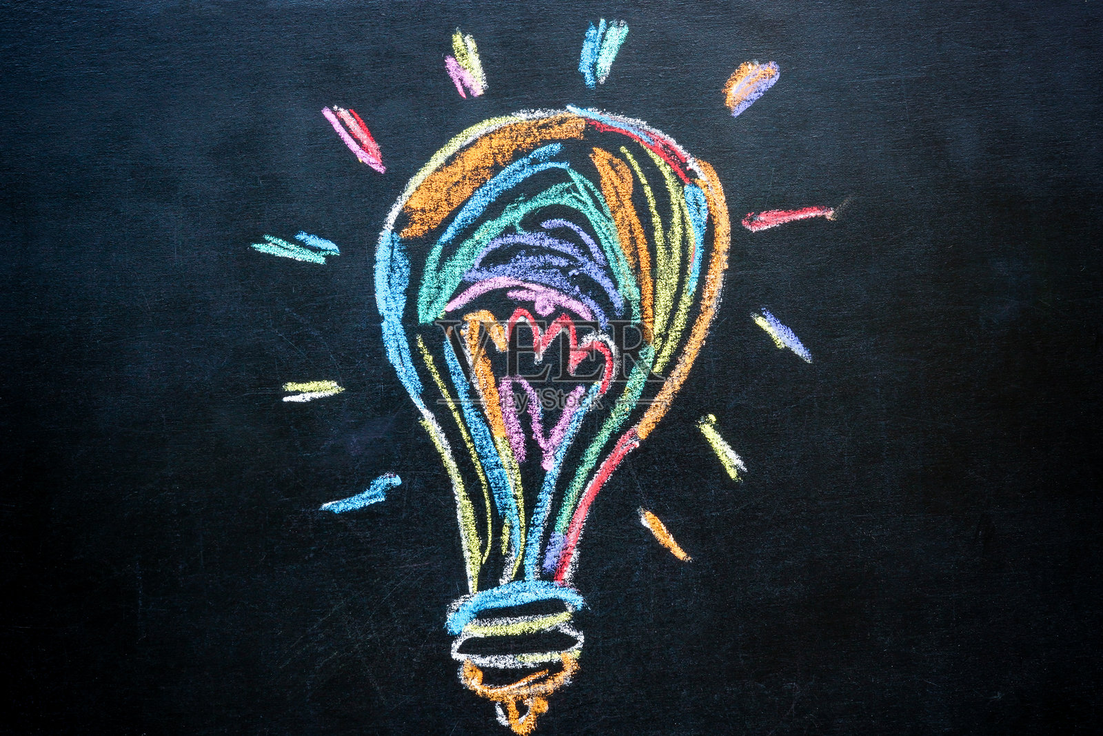 创造力和新想法。用彩色粉笔在黑板上画的灯泡。照片摄影图片