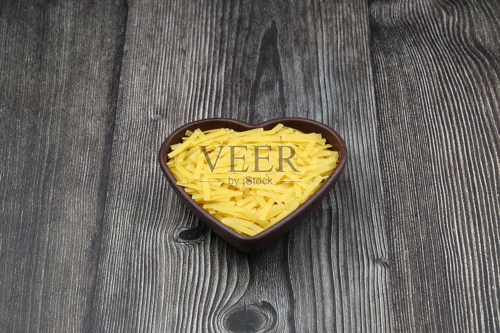 手工土耳其面(土耳其名字:Eriste)在碗。传统土耳其菜中的Erishte。木制背景上的粉丝。照片摄影图片