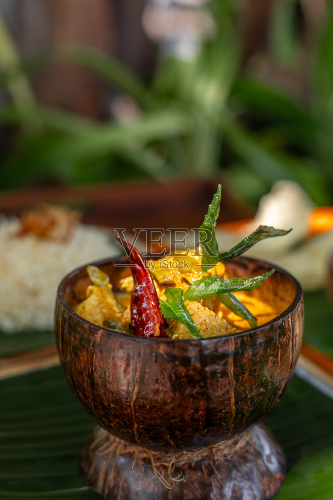 马尔代夫椰子咖喱菜，配金枪鱼、茉莉花米饭和桑巴酸辣酱，配椰子壳和香蕉叶照片摄影图片