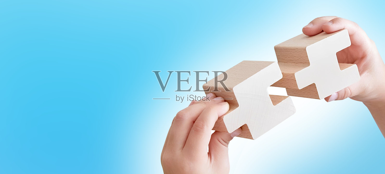 商业成功的伙伴关系或团队合作的概念。双手合并木制拼图。照片摄影图片