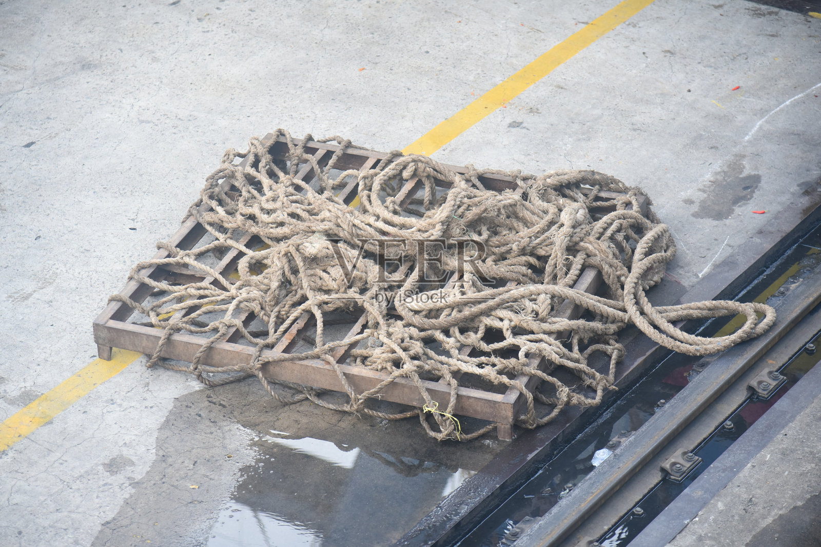 旧船停泊在港口。船绳磨损。巨大的航海肮脏破旧的白色绳索背景纹理近距离。绳索的选定焦点。近距离模式污垢旧船绳索。纹理照片摄影图片