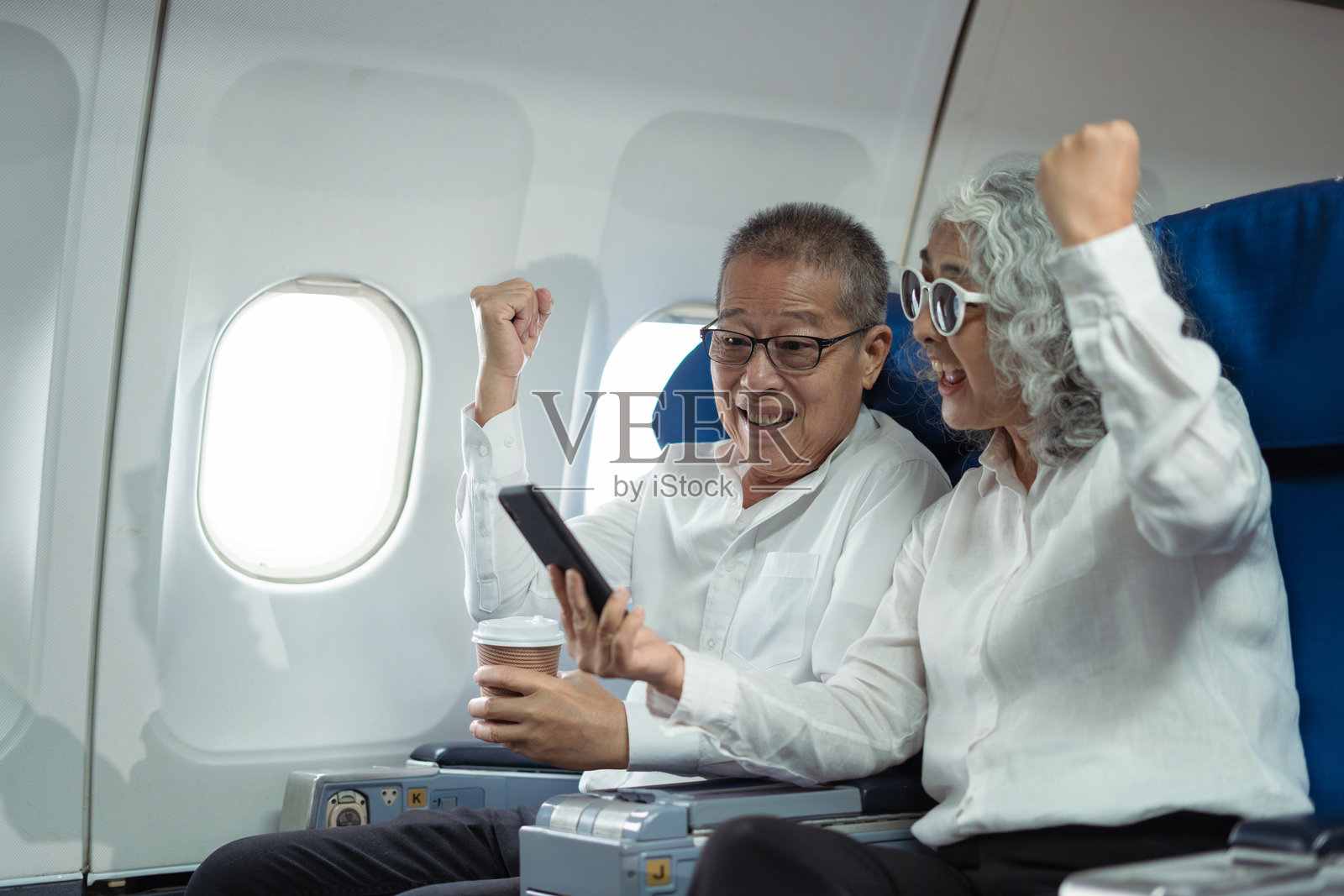 一对成熟的夫妇坐在私人飞机上，准备去旅行照片摄影图片