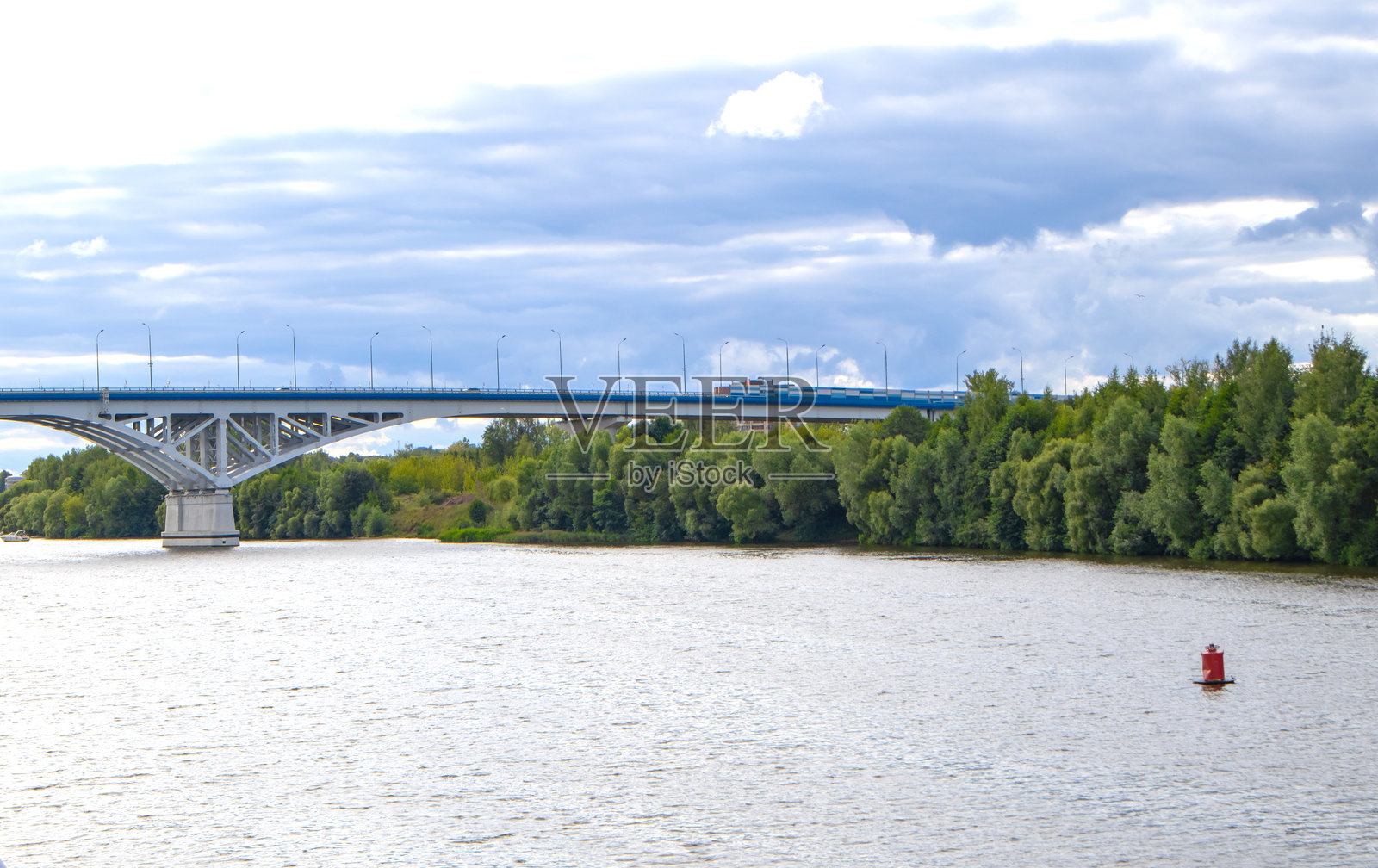 多云的天空下，宽阔的河流上一座巨大的汽车桥照片摄影图片