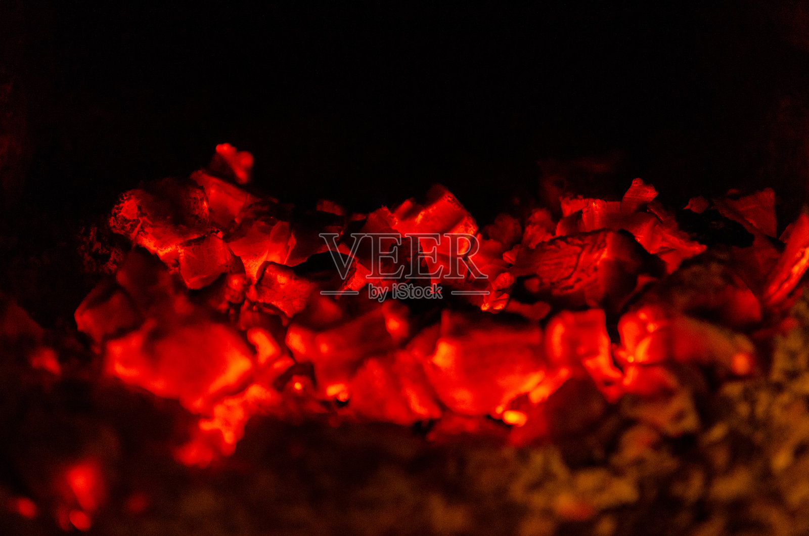 壁炉里炙热的红煤的特写镜头。照片摄影图片