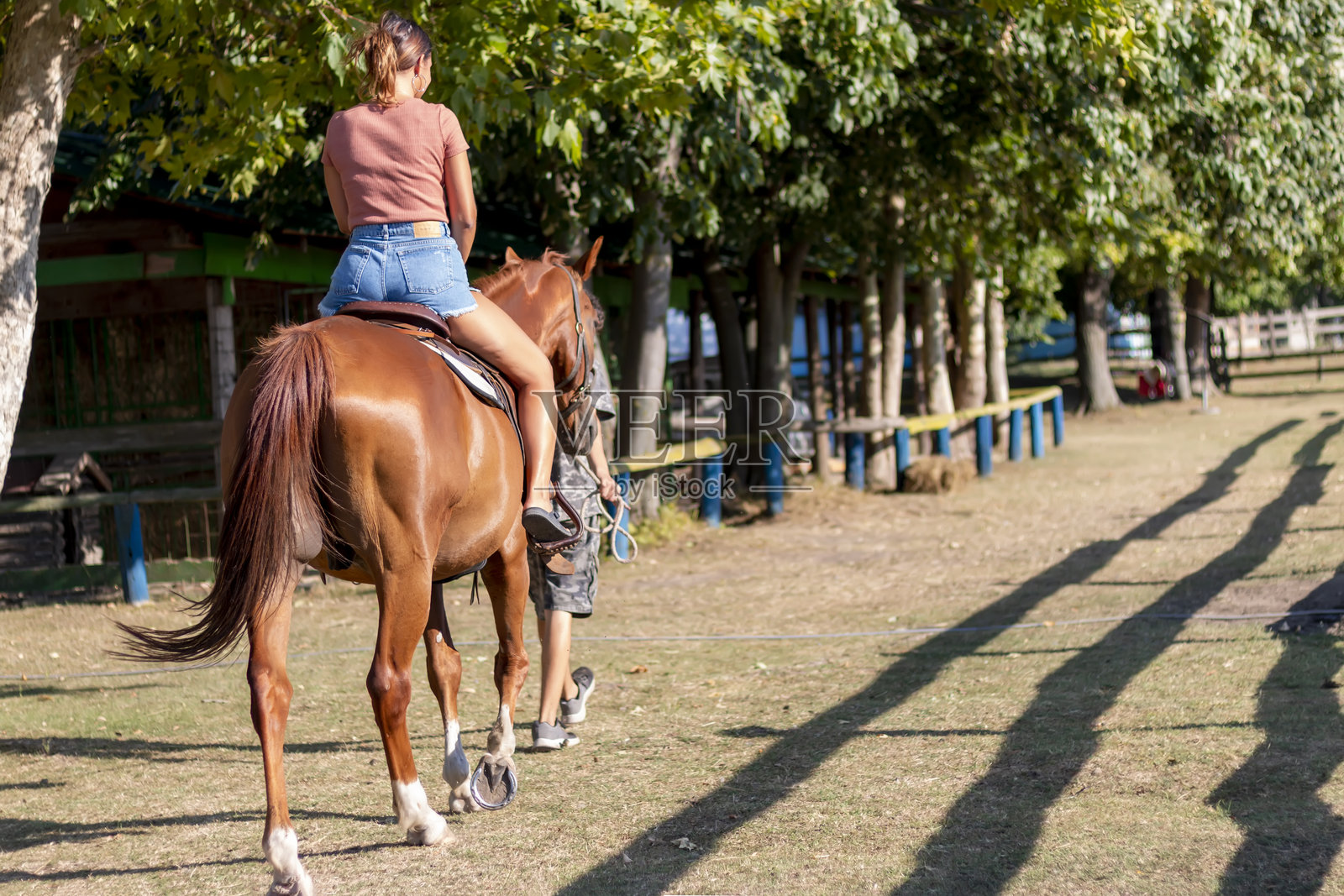 一位年轻女子和教练在乡间骑马照片摄影图片