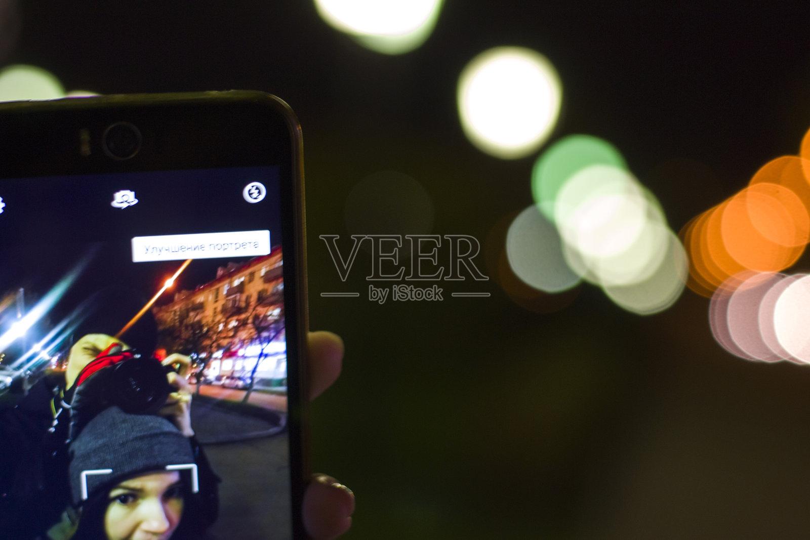 晚上在灯火通明的城市里，男子在朋友自拍时拍照照片摄影图片