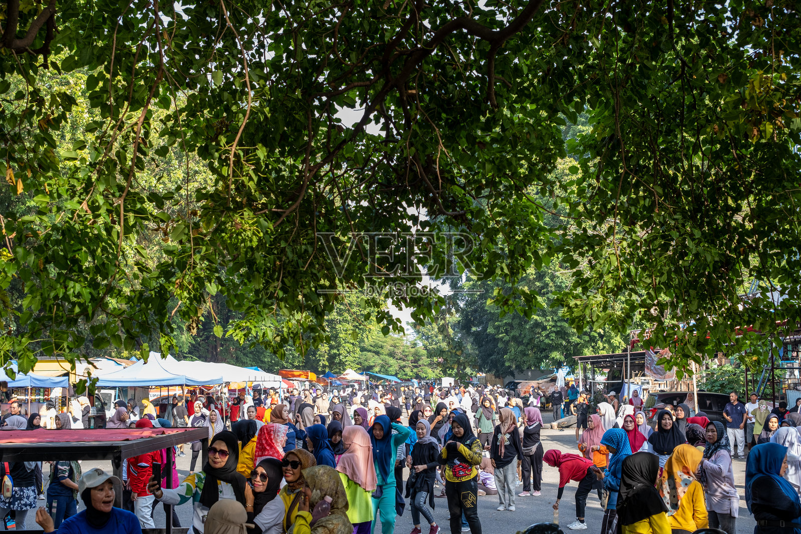 一群戴着头巾的成年和十几岁的妇女在假期一起在野外做有氧运动后聚集在一起照片摄影图片