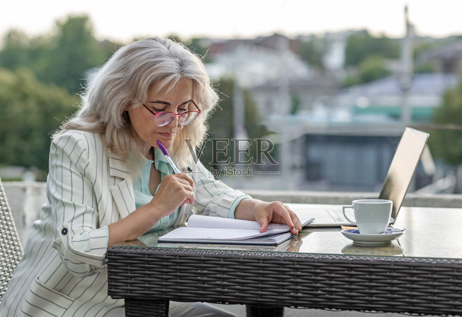 在咖啡馆上网的女商人，有城市背景照片摄影图片