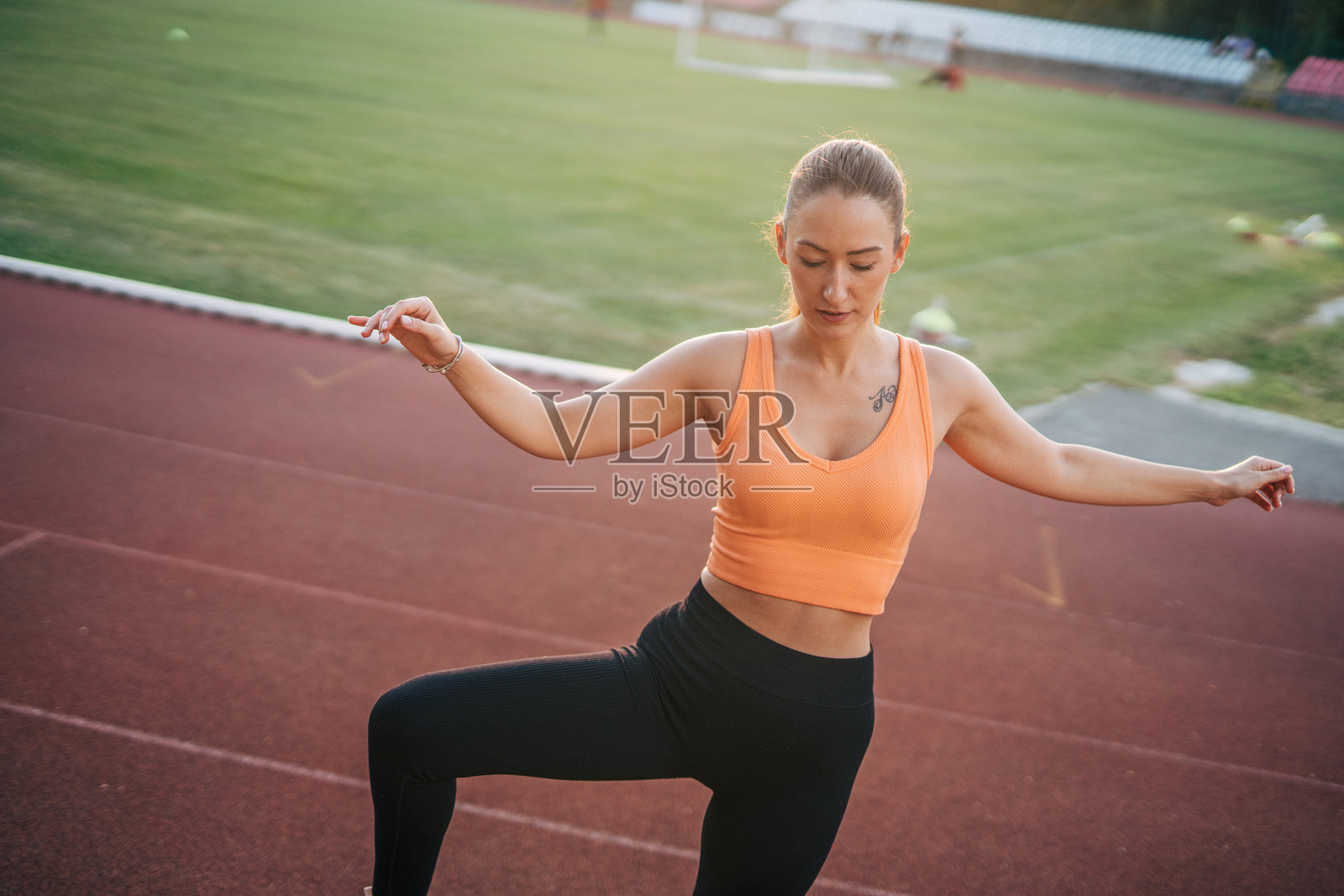 一位年轻女子正在户外跑道上锻炼照片摄影图片