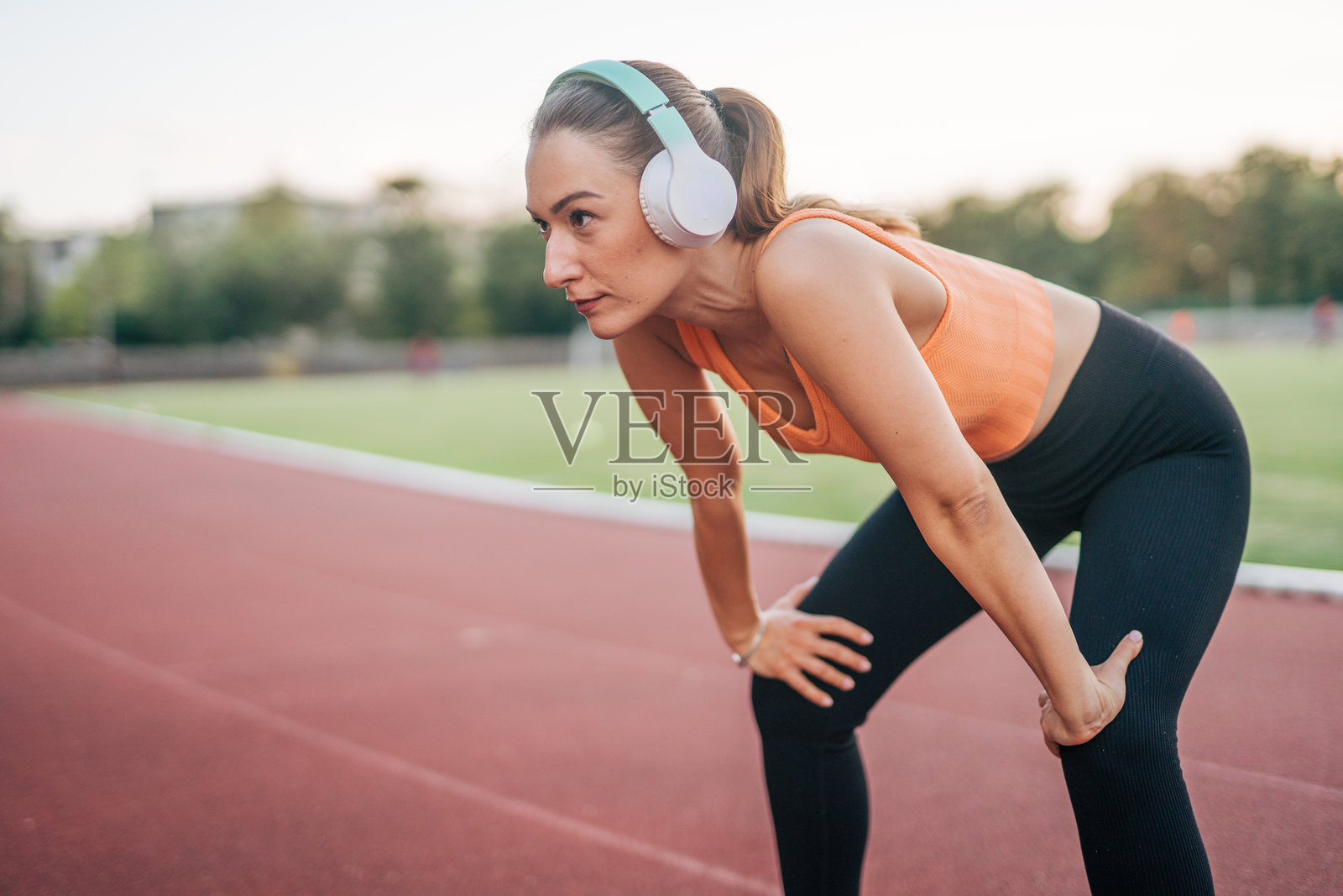 一位年轻女子正在户外跑道上锻炼照片摄影图片
