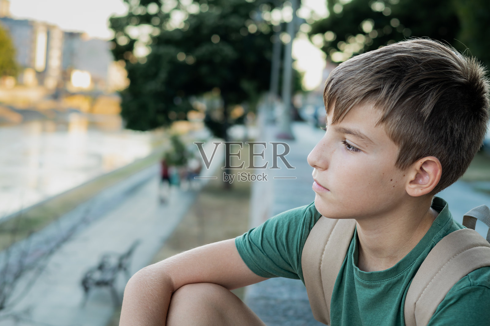 回到学校。第一天上学后，公园里一个男孩背着书包的照片。照片摄影图片