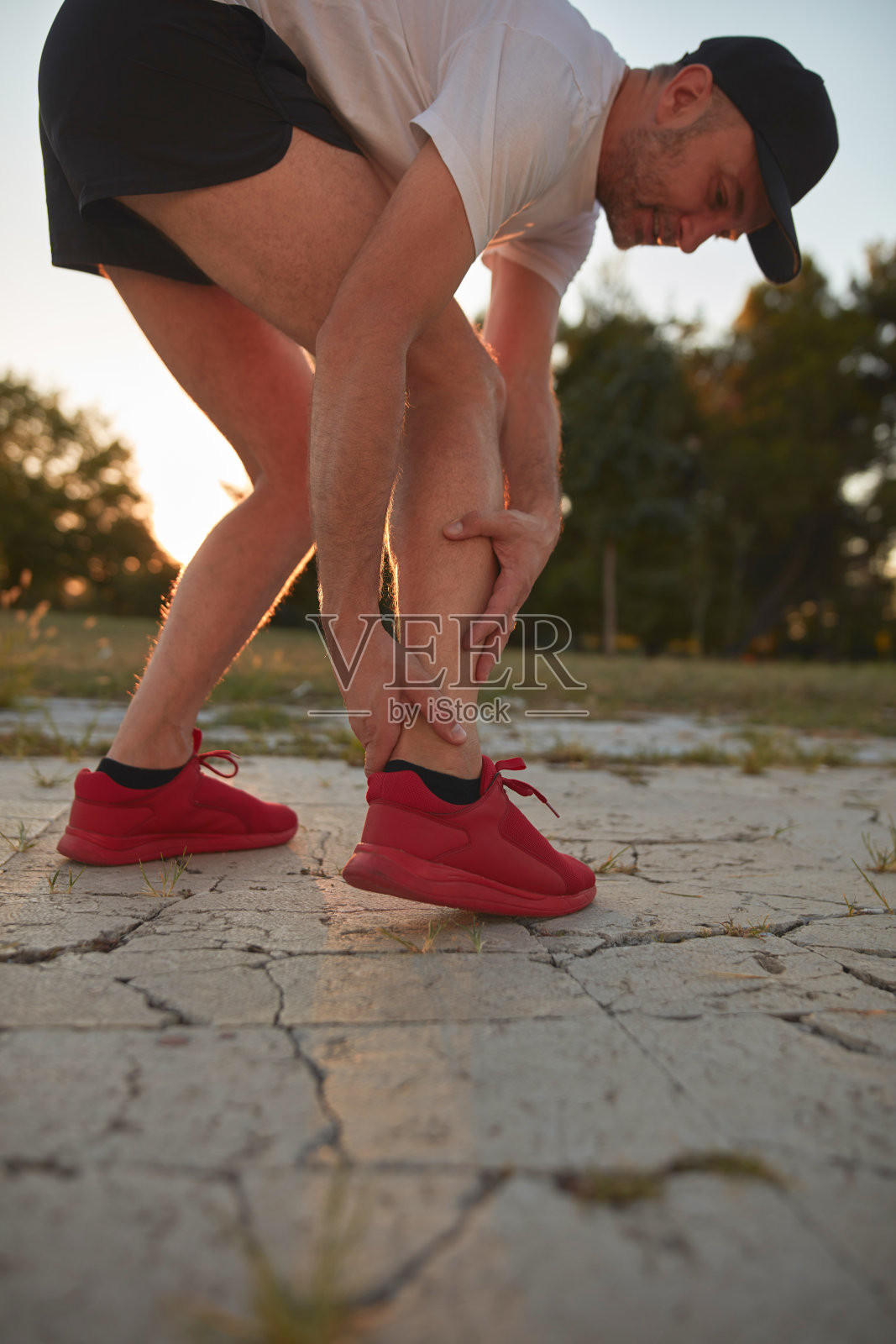 男子在公园慢跑及运动时脚踝受伤及疼痛。照片摄影图片