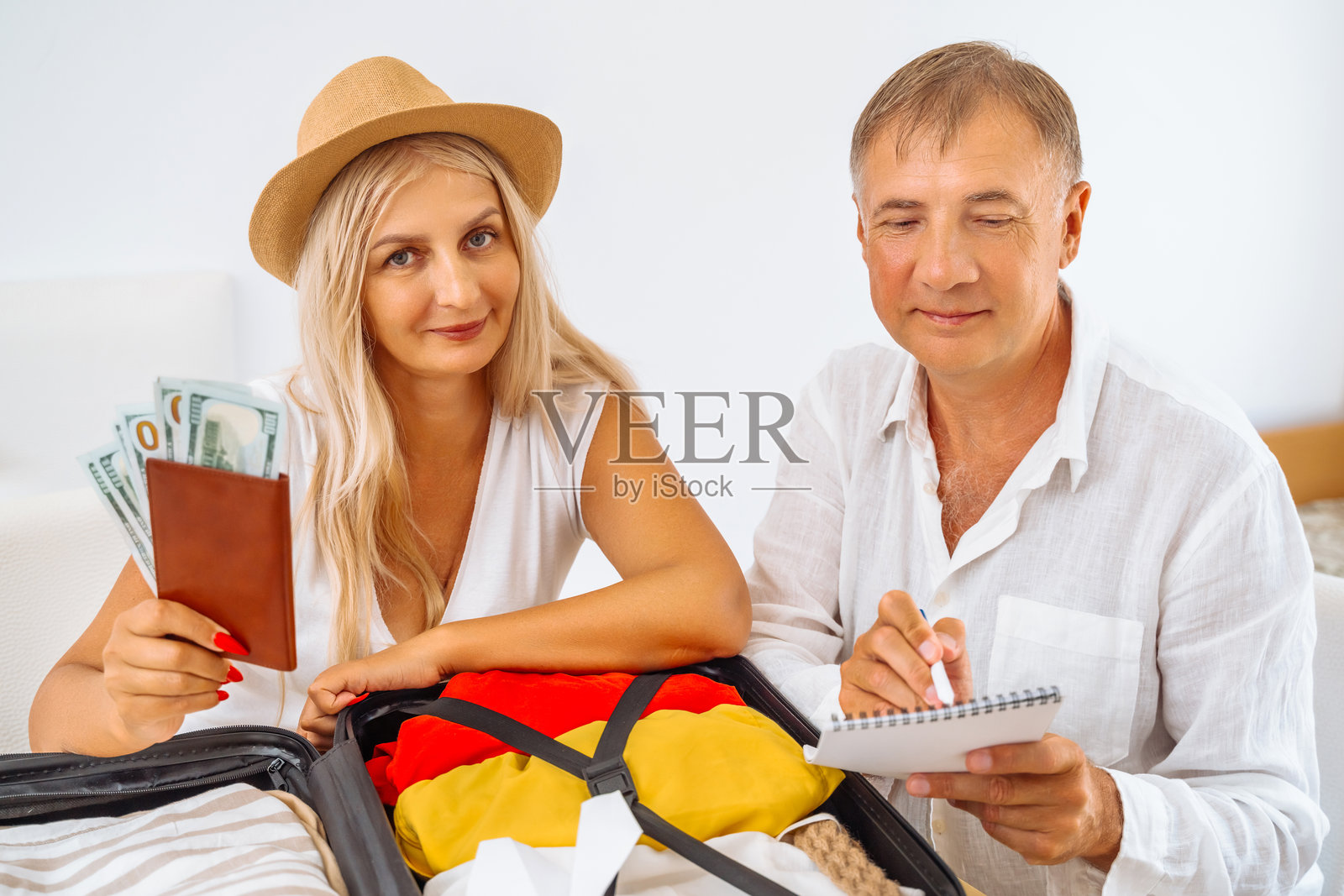 男人和女人正在收拾行李，准备去旅行。照片摄影图片