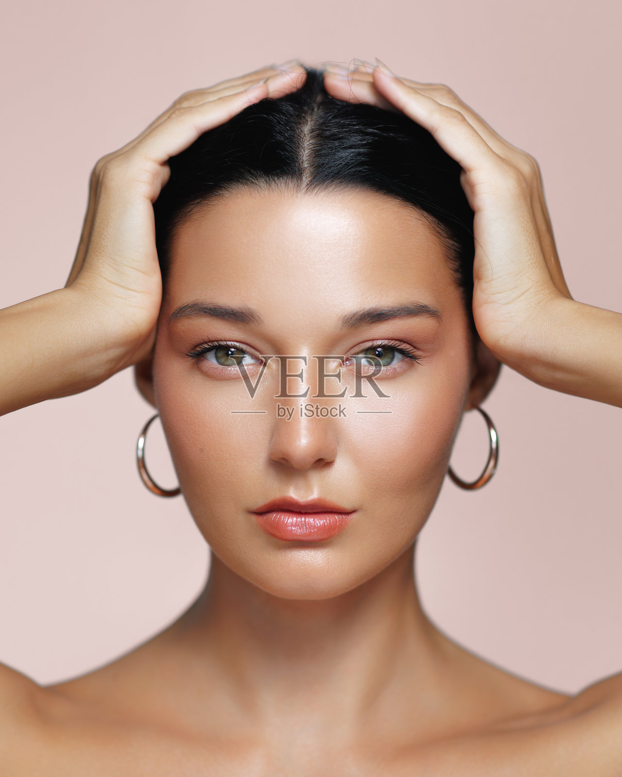 时尚拉丁女人与发光的晒黑皮肤和环形耳环照片摄影图片