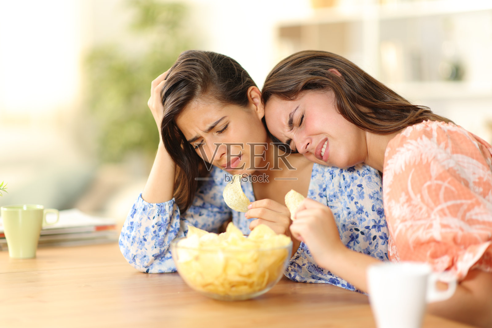 两个情绪低落的朋友在吃薯片照片摄影图片