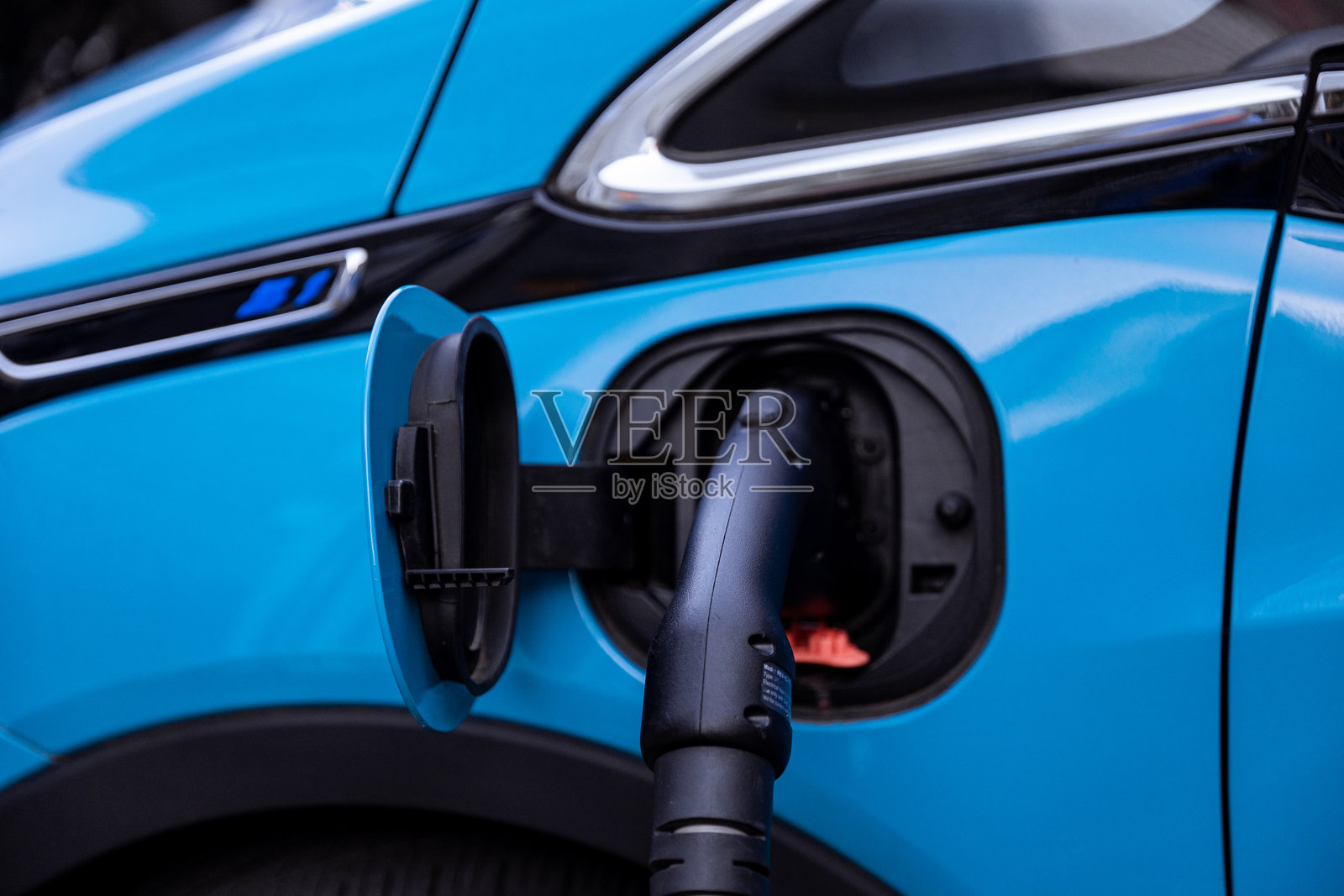 在公共充电站为现代蓝色电动汽车充电照片摄影图片