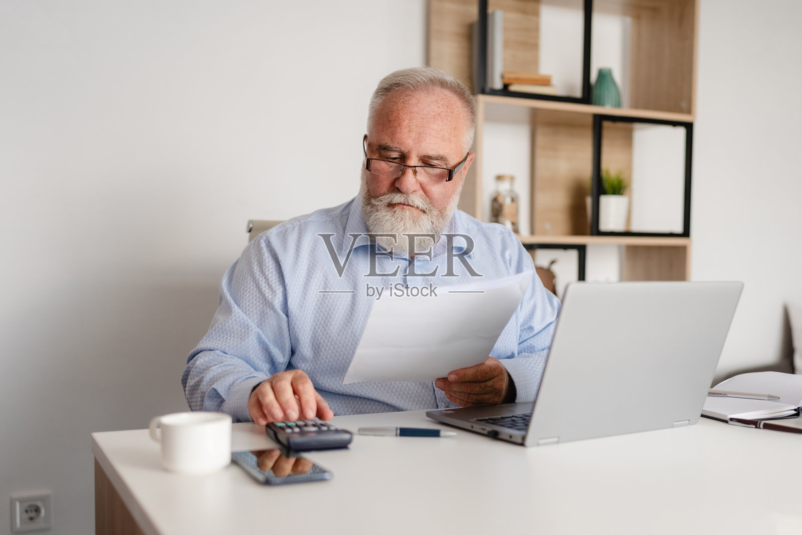 成熟的商人在办公室里做财务计算照片摄影图片