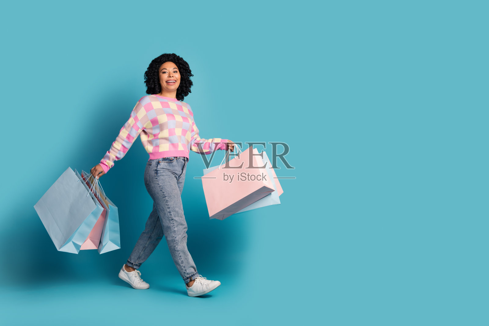 迷人的年轻女子的全身照片走购物袋横幅穿着时尚的粉红色格纹衣服孤立的蓝色背景照片摄影图片