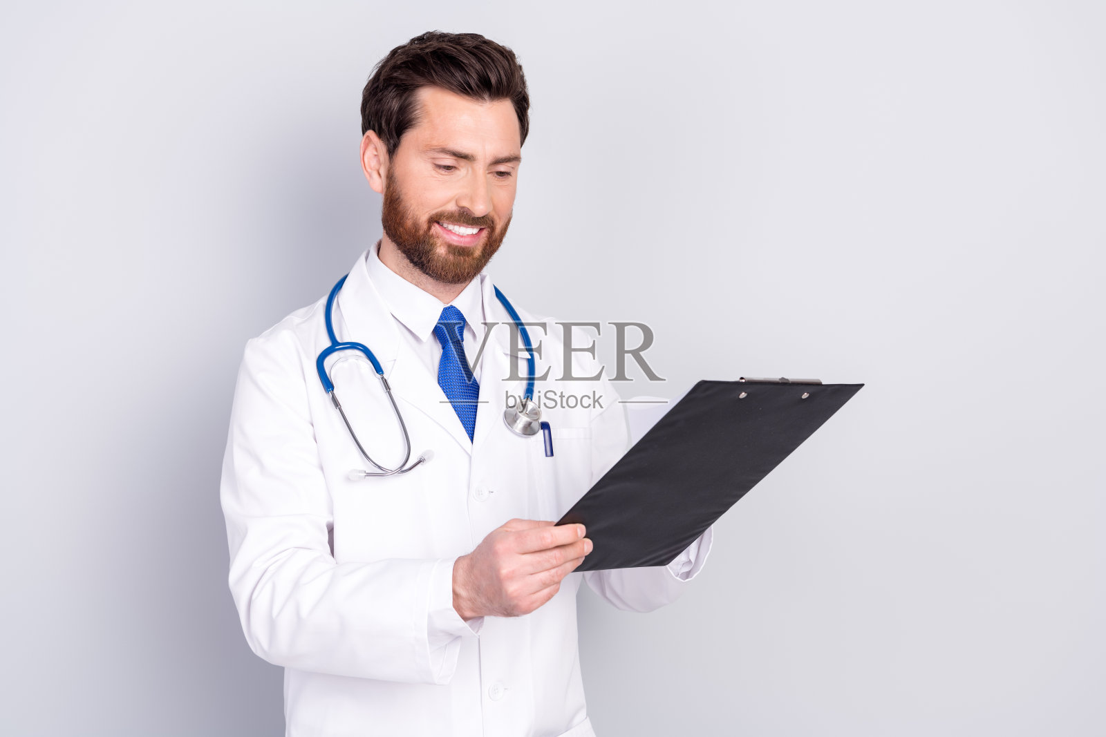 照片的医生治疗师合格的专家穿着制服分析医疗卡隔离在灰色背景照片摄影图片