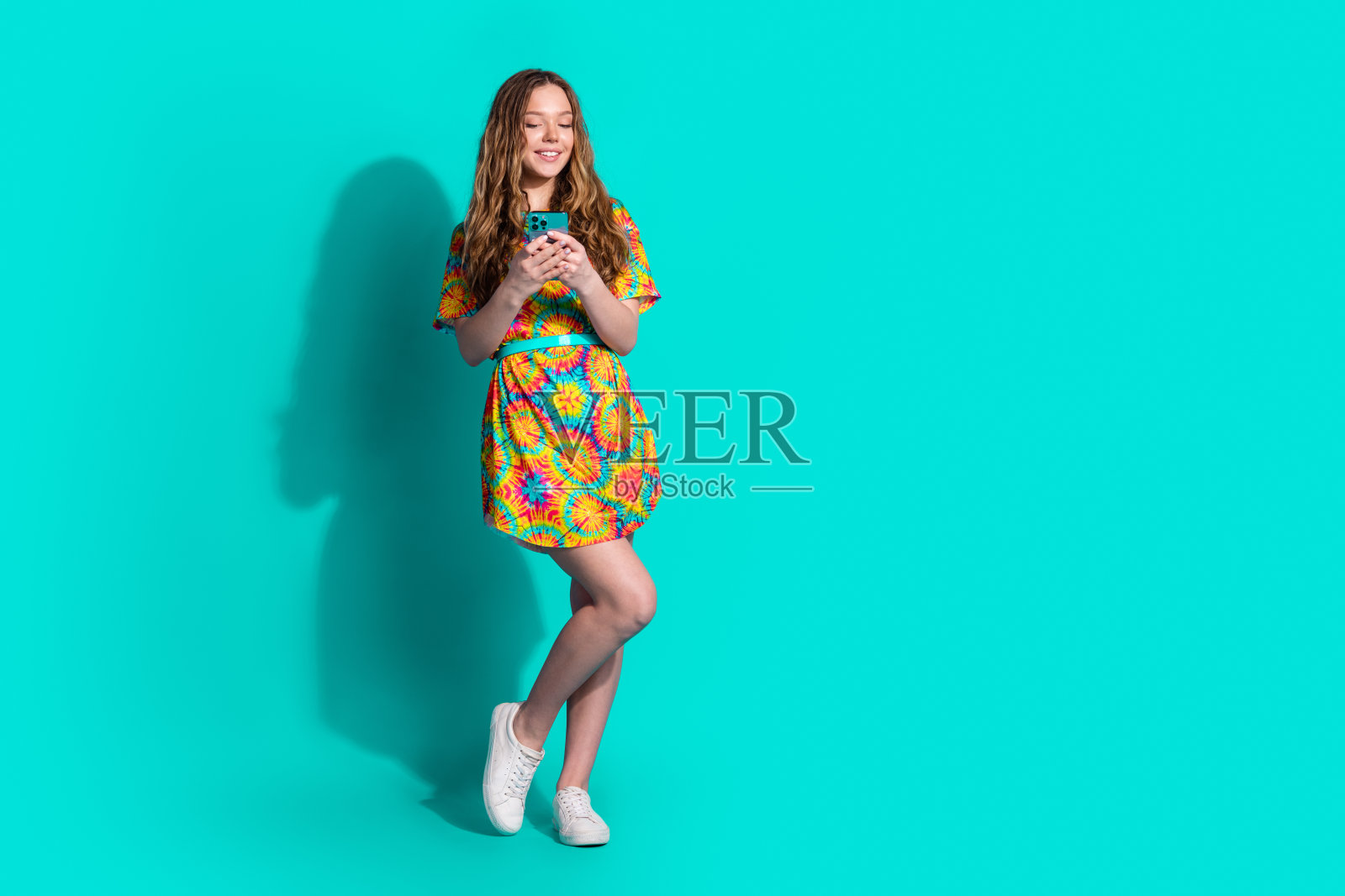 可爱的少女女士手持设备穿着时尚的彩色服装孤立的青色背景的完整的照片照片摄影图片