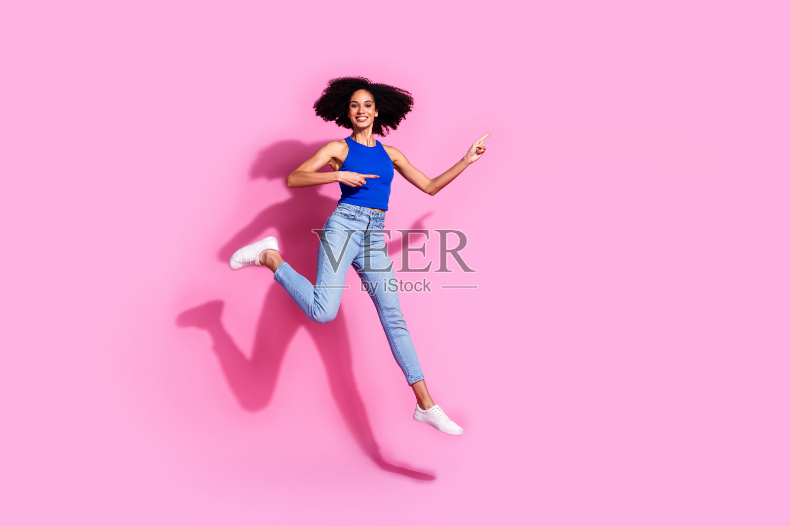 迷人的年轻女子的全身照片跑点空白穿着时尚的蓝色衣服孤立的粉红色背景照片摄影图片