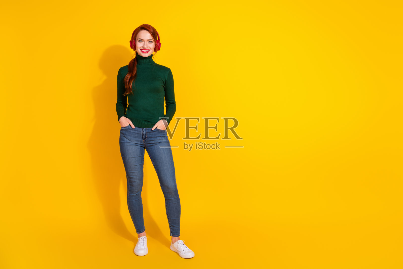 全身照片光泽迷人的女士穿着绿色毛衣享受歌曲耳机空的空间孤立的黄色背景照片摄影图片