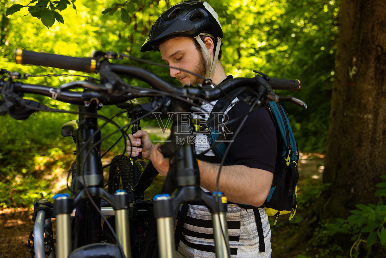 年轻的MTB骑手戴着头盔从自行车车拖上山骑山地自行车照片摄影图片