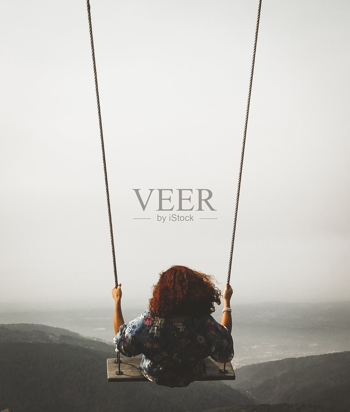 女子在空中荡秋千的后视图照片摄影图片