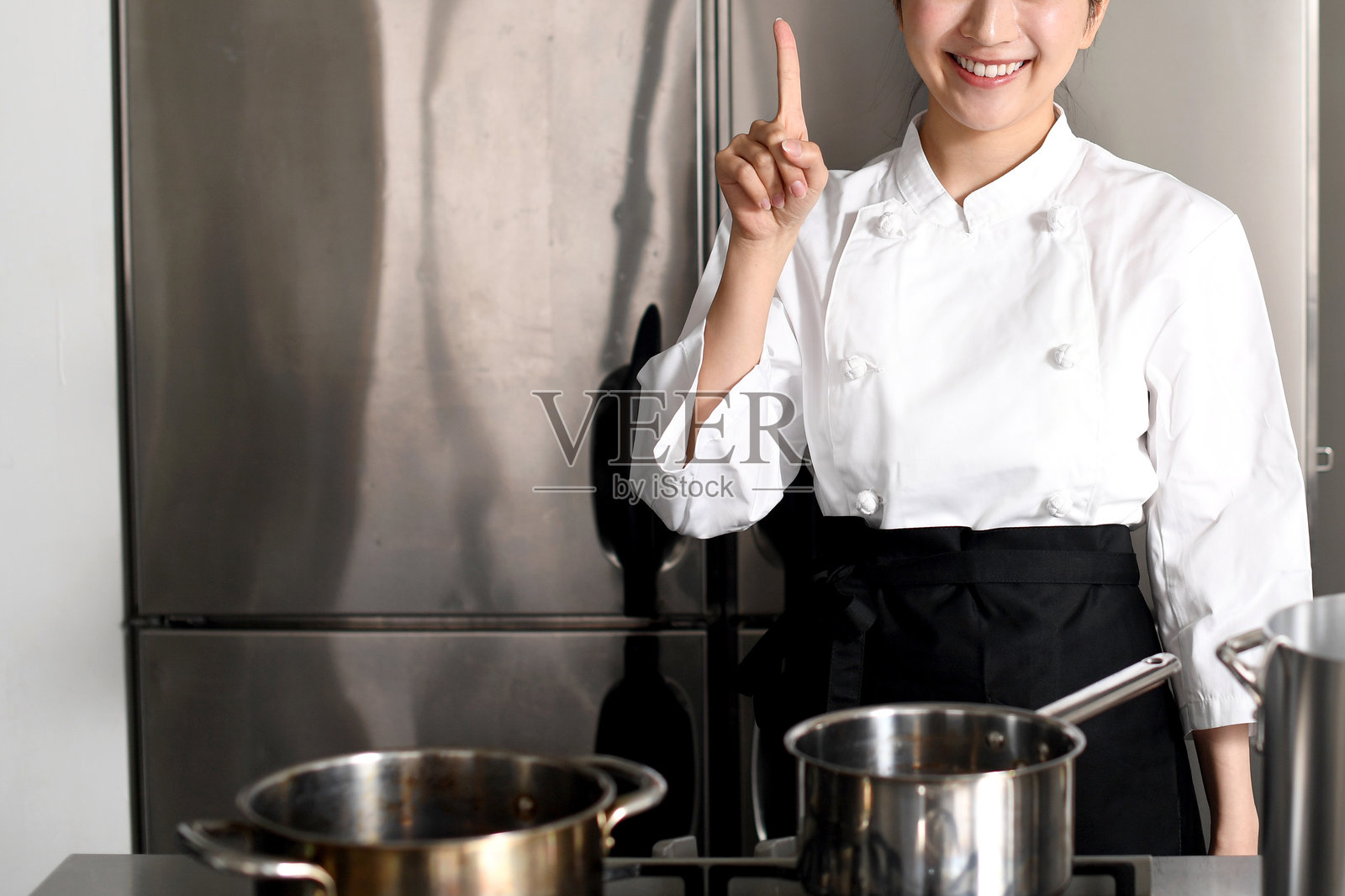 亚洲年轻女性厨师在厨房做饭照片摄影图片