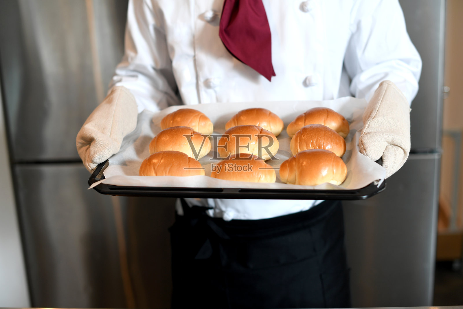 面包师穿着厨师服的手在厨房里做面包照片摄影图片