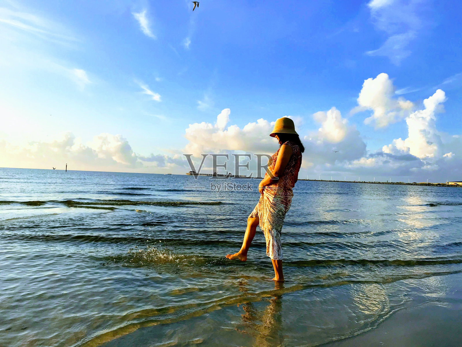 站在沙滩上的女人对着天空照片摄影图片