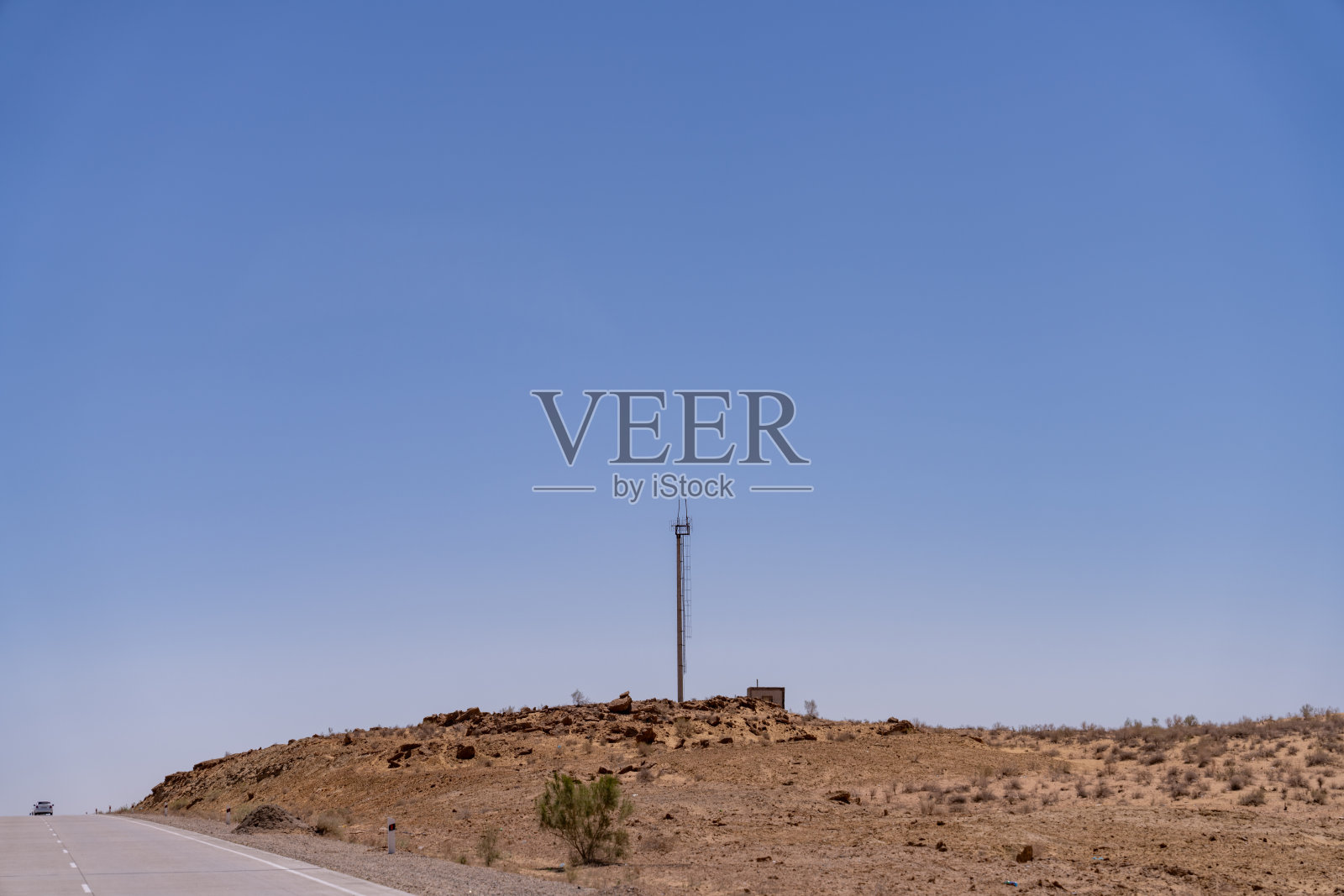 沙漠中的电线杆和行驶的汽车照片摄影图片