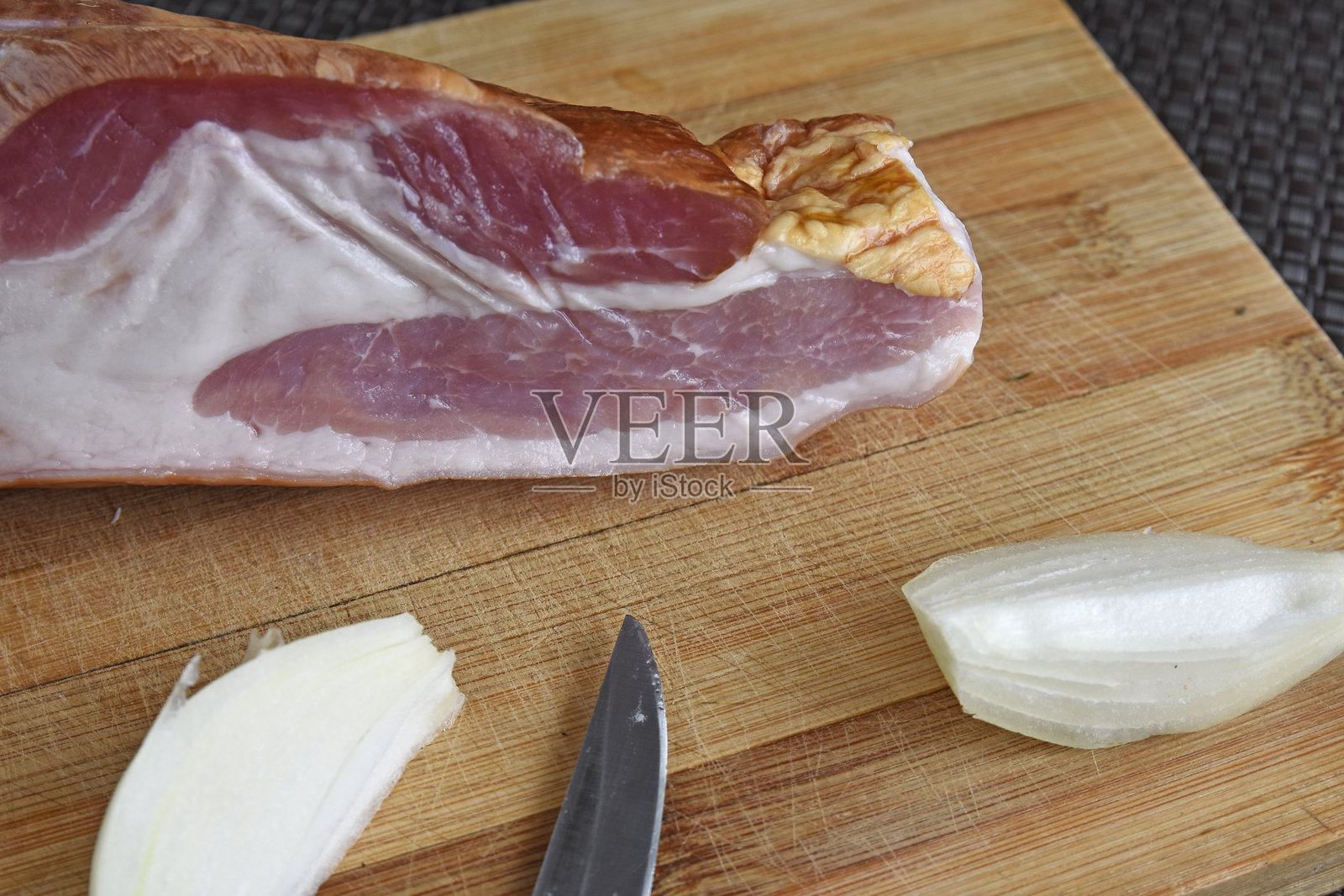 在案板上放一片培根，配上刀和洋葱照片摄影图片