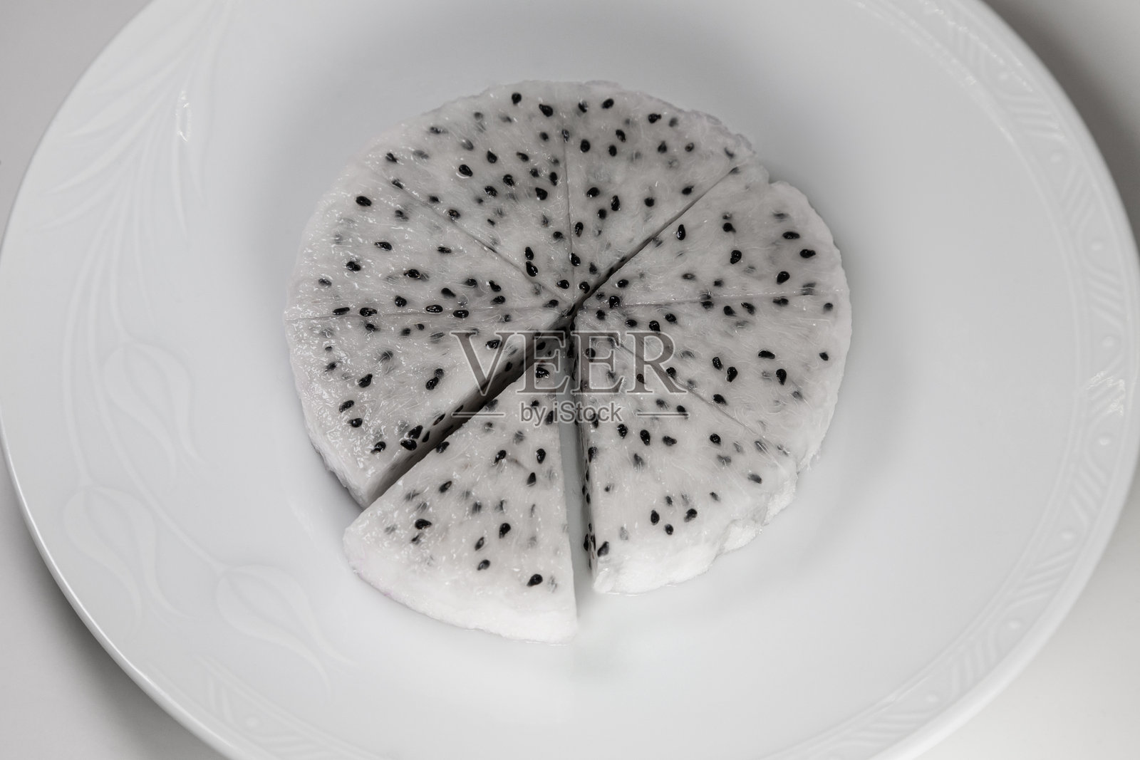 在碟子里的火龙果孤立在白色背景上。照片摄影图片