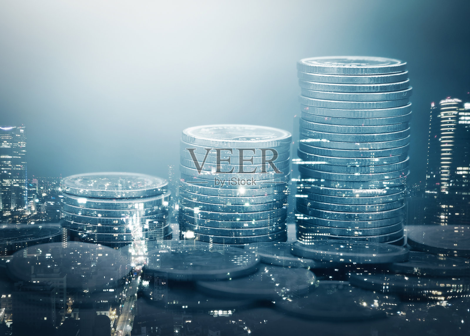 一叠硬币在城市灯光下的双重曝光照片摄影图片