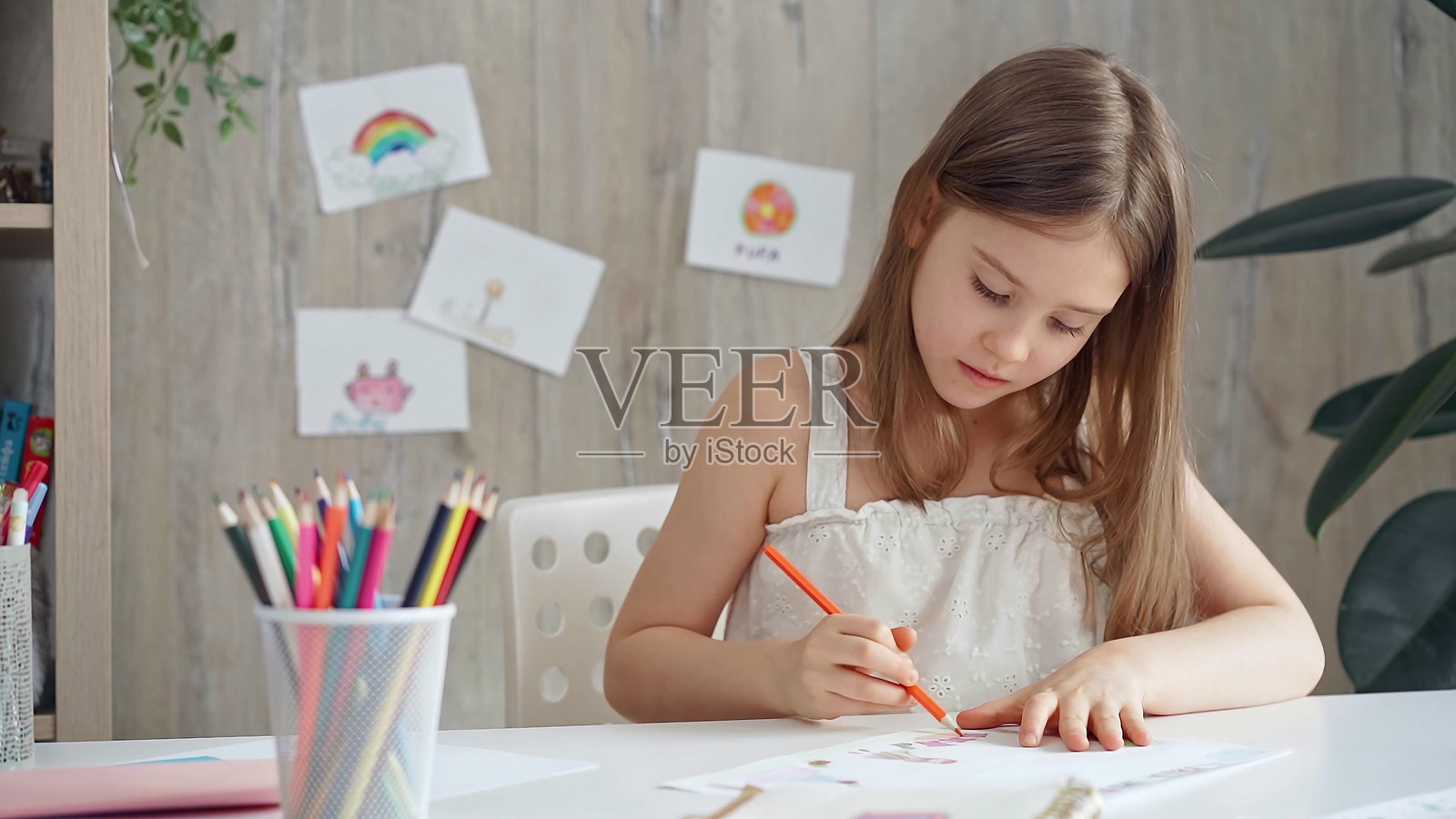 有创造力的孩子在家里或学校教室的课桌上画画照片摄影图片