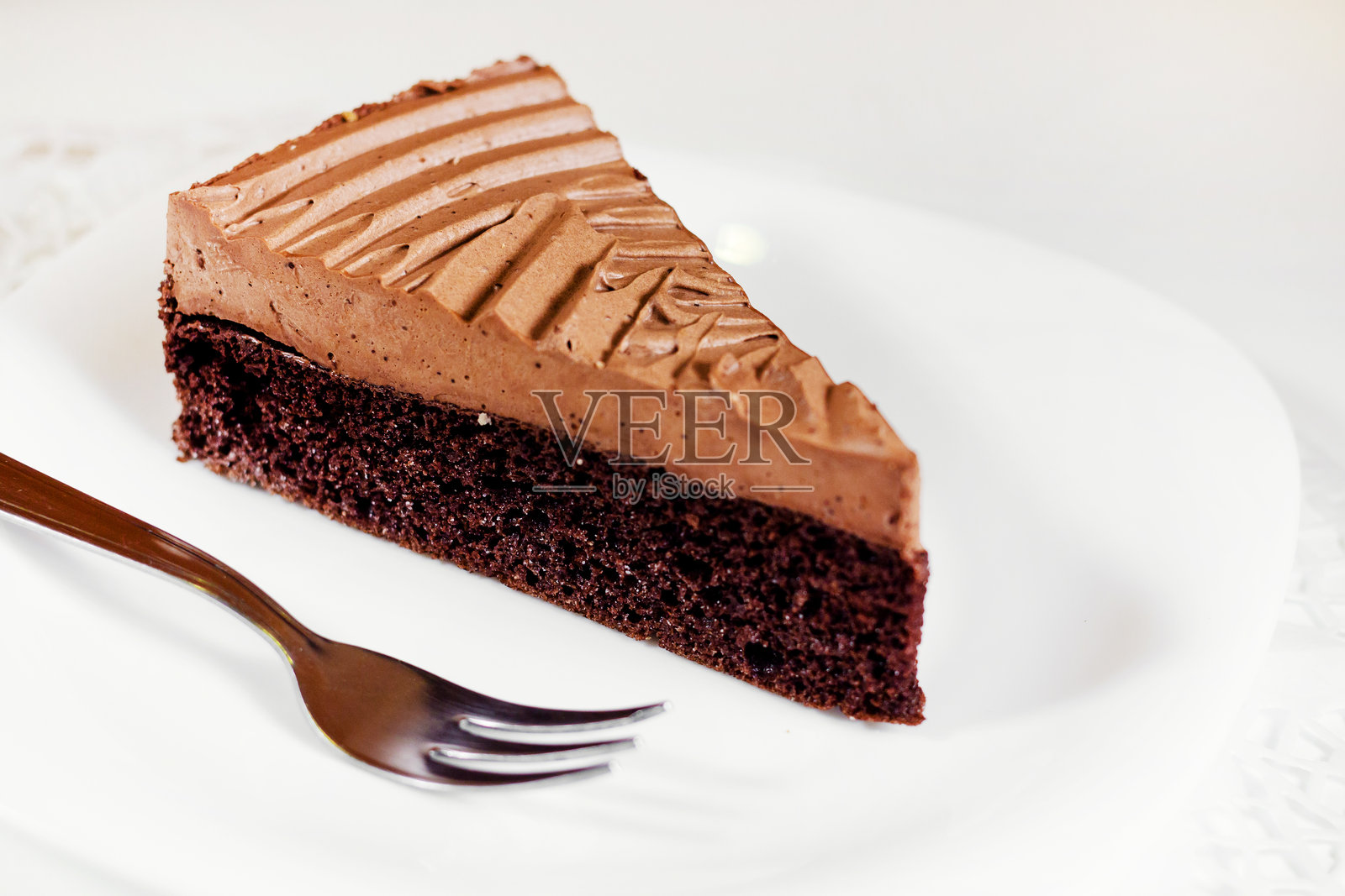 白色背景上盘子里的巧克力蛋糕特写照片摄影图片