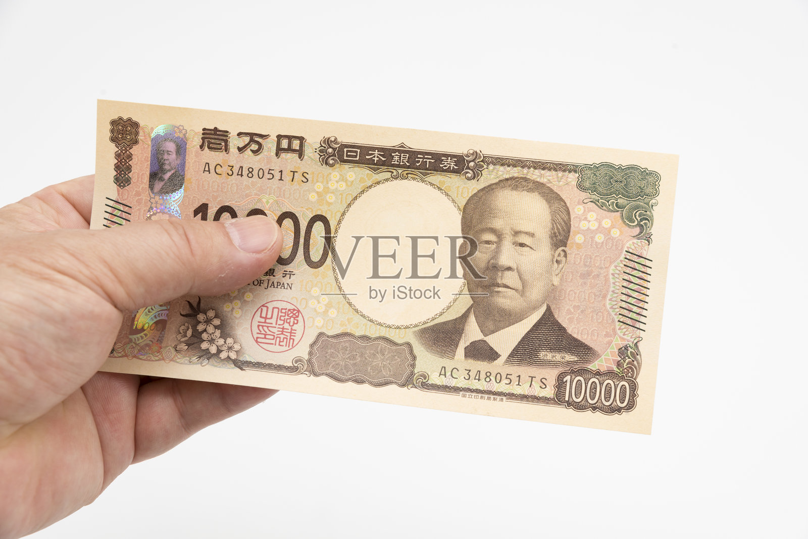 男子手持新发行的日本1万日元纸币，白色背景孤立照片摄影图片