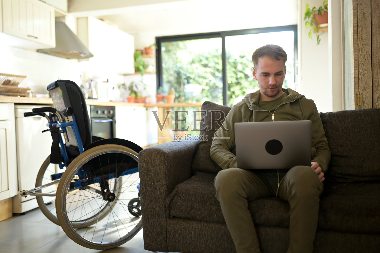 有行走障碍的年轻人在用笔记本电脑照片摄影图片