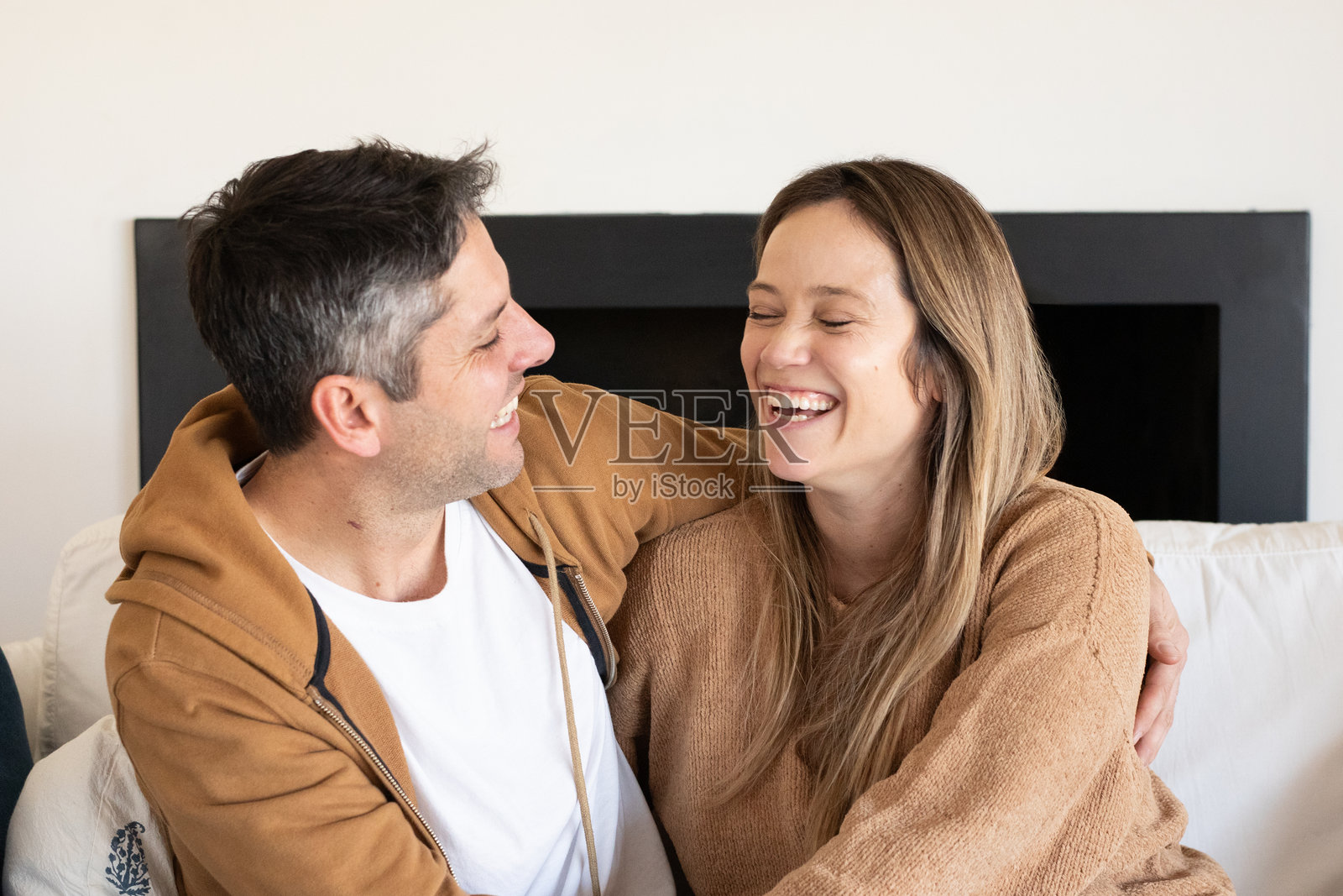 年轻夫妇在他们家的客厅里拥抱照片摄影图片